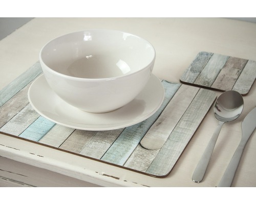 Gedeckter Tisch mit weißer Schüssel, Teller, Besteck und Untersetzern im Holzdesign