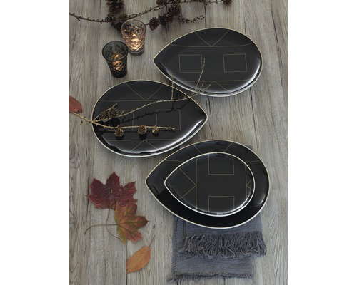 Dekoratives Arrangement mit schwarzen Tellern mit geometrischem Muster