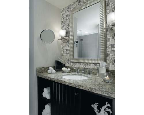 Badezimmer mit Spiegel, Waschbecken, Waschtisch und Mosaikfliesen