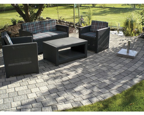 Gartenmöbel-Set auf Steinterrasse mit Rasenfläche