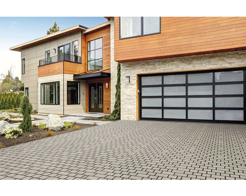 Modernes Haus mit Pflastersteineinfahrt und Garage mit Glastor