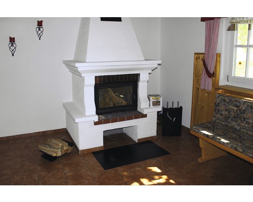 Gemauerter Kamin mit Brennholz, Kaminbesteck und Bank