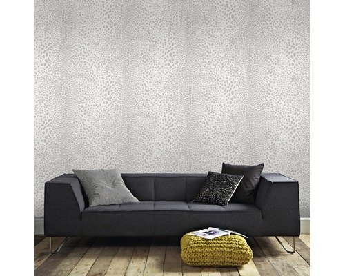 Wohnzimmer mit gemusterter Tapete und dunklem Sofa