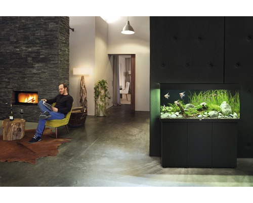 Wohnzimmer mit Aquarium, Kamin und lesendem Mann