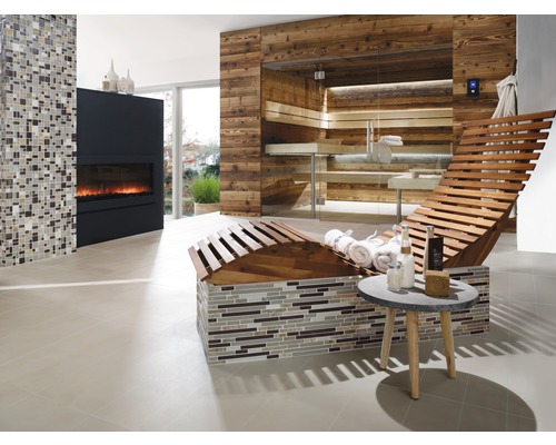 Heller Wellnessbereich mit Sauna, Liege, Kamin und Mosaikwand