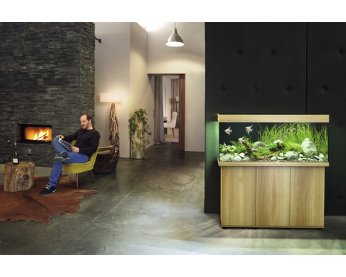 Wohnzimmer mit Aquarium, Kamin und lesendem Mann