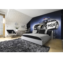 Helles Schlafzimmer mit Bett, Schreibtisch und Fototapete eines Polizeiautos