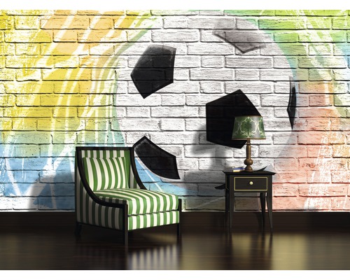 Wohnzimmer mit Sessel, Beistelltisch und einer Wand mit Fußballmotiv