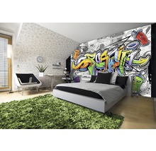 Modernes Schlafzimmer mit Graffiti-Fototapete, Bett, Schreibtisch und grünem Teppich.