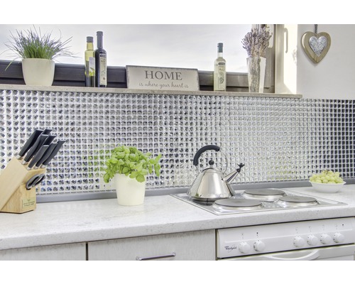 Helle Küche mit Mosaikfliesen, Kochfeld, Wasserkocher und dekorativen Elementen.