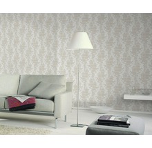 Wohnzimmer mit gemusterter Tapete, Stehlampe und Sofa