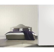 Schlafzimmer mit gemusterter Tapete und Bett