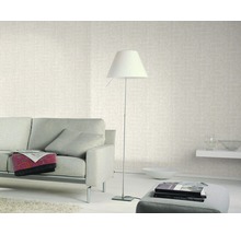 Wohnzimmer mit Sofa, Stehlampe und gemusterter Tapete für eine helle und freundliche Atmosphäre.