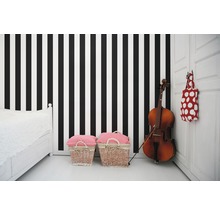 Zimmer mit gestreifter Tapete, Bett, zwei Körben und Cello