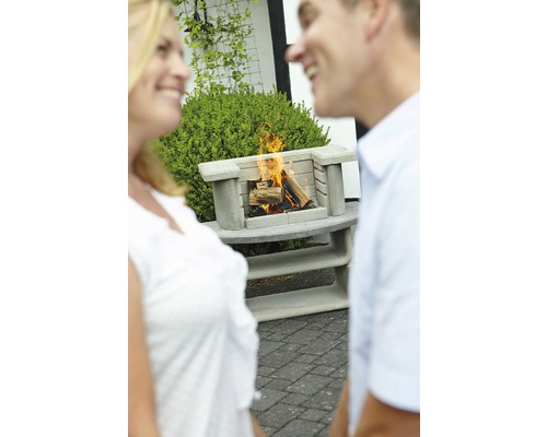 Beton Außengrillkamin mit brennendem Holz und zwei Personen