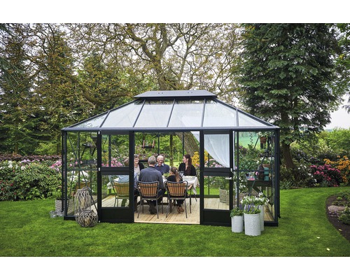 Gewächshaus mit Familie beim Essen im Garten