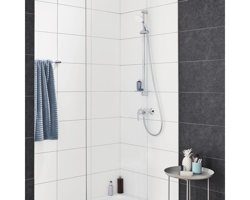 Modernes Badezimmer mit Duscharmatur, Handtuch und dekorativen Elementen