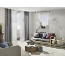 Wohnzimmer mit Sofa, Sessel, Vorhängen und dekorativen Elementen für ein gemütliches Ambiente.