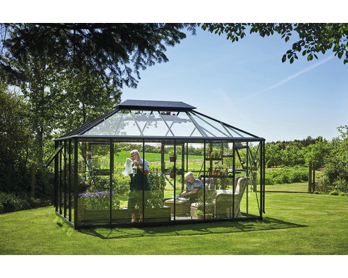 Gewächshaus im Garten mit Personen, Pflanzen und Sitzmöbeln.