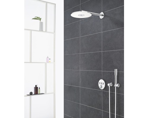 Badezimmer mit Kopfbrause und Armaturen an gefliester Wand