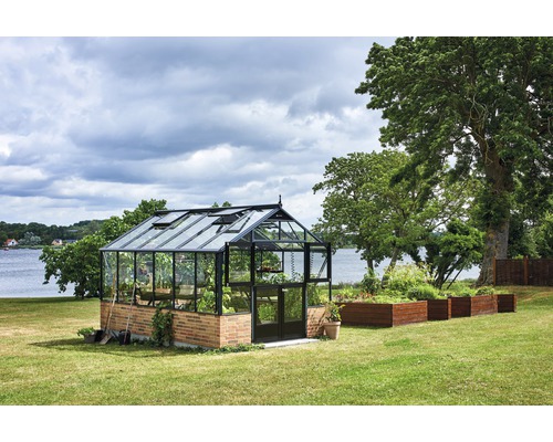 Gewächshaus im Garten mit Hochbeeten und Bäumen