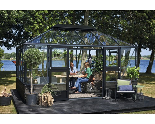 Gewächshaus mit Personen auf einer Terrasse im Garten.