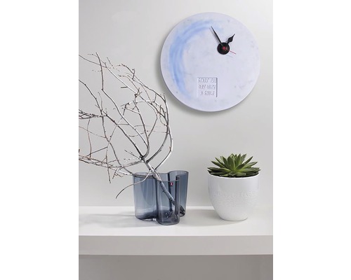 Dekorative Szene mit Wanduhr, Vase mit Ästen und Topfpflanze auf einem Regal