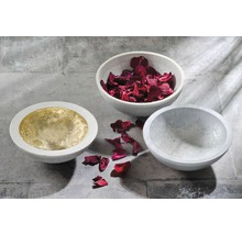 Drei Betonschalen, eine mit Gold ausgelegt, eine mit Rosenblättern gefüllt, eine leer.