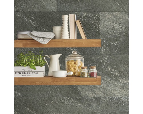 Dekorative Küchenszene mit Regalen, Geschirr, Zutaten und grauen Wandfliesen.