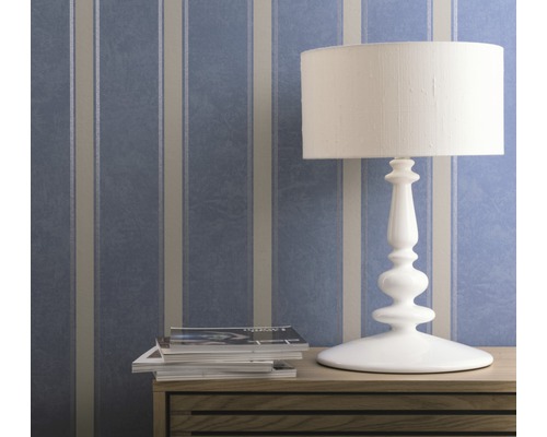 Dekorative Tapete mit Streifenmuster hinter einer Tischlampe und Zeitschriften