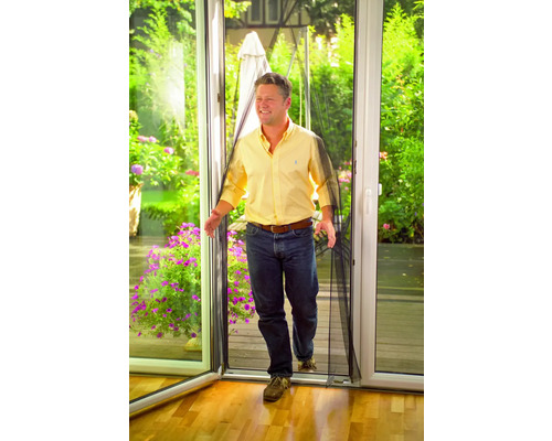 Mann geht durch eine Tür mit Insektenschutzgitter.