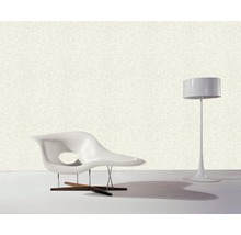 Einrichtungsszene mit einem Sessel aus Kunststoff, einem Holzfuß und einer Stehlampe.