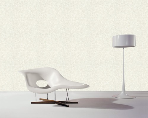 Einrichtungsszene mit einem Sessel aus Kunststoff, einem Holzfuß und einer Stehlampe.