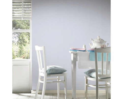 Helles Esszimmer mit weißem Tisch, Stühlen und blau gestrichener Wand