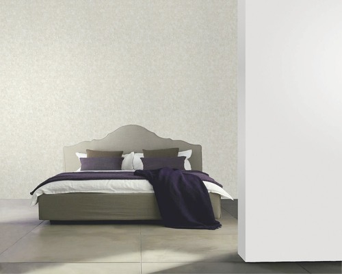 Schlafzimmer mit Bett, Kissen und Tapete an der Wand.