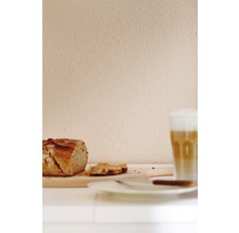 Stillleben mit Brotlaib, Brotscheiben und Latte Macchiato auf einem Tisch.