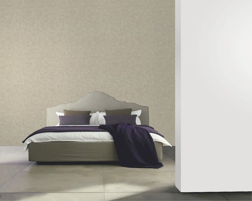 Schlafzimmer mit einem Bett und gemusterter Tapete.