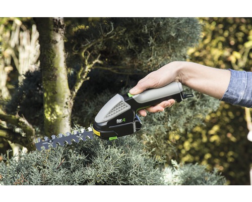 Akku-Grasschere im Einsatz beim Beschneiden einer Pflanze