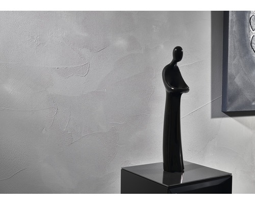 Wandgestaltung mit Putzstruktur und dekorativer Figur auf einem Schrank