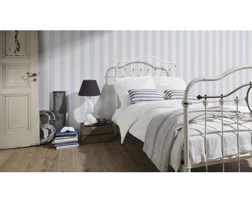 Schlafzimmer mit gestreifter Tapete, Bettgestell aus Metall und Holzboden