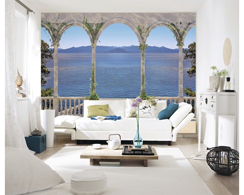 Wohnzimmer mit Fototapete mit Landschaftsmotiv, die eine Veranda mit Blick auf das Meer zeigt.