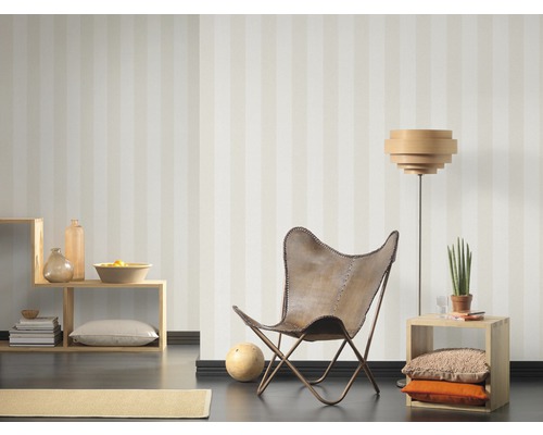 Wohnraum mit gestreifter Tapete, Sessel, Stehlampe und Regalen zur Dekoration