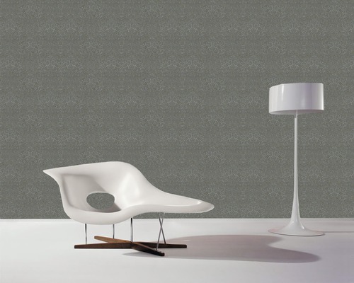 Raumansicht mit gemusterter Tapete, Sessel und Stehlampe