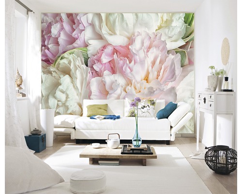 Wohnzimmer mit Fototapete mit Pfingstrosenmuster, Sofa und Wohnaccessoires.