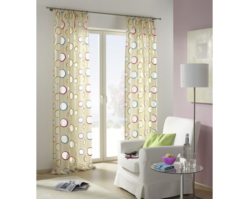 Dekorativer Vorhang mit Kreismuster vor einem Fenster in einem Wohnzimmer.