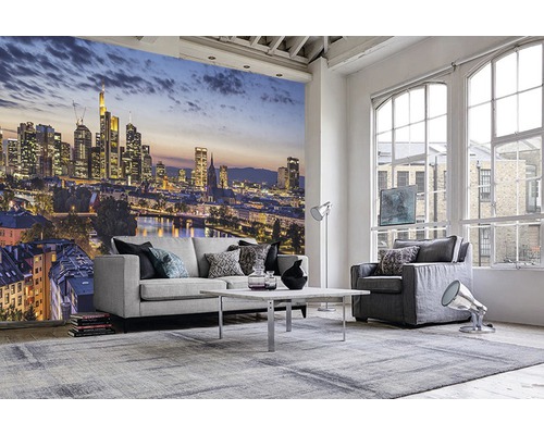 Wohnzimmer mit Fototapete einer Skyline, Sofa, Sessel und Teppich