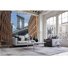 Wohnraum mit Fototapete, die eine Brücke und Gebäude zeigt, mit Sofa, Sessel und Teppich