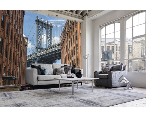 Wohnraum mit Fototapete, die eine Brücke und Gebäude zeigt, mit Sofa, Sessel und Teppich