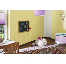 Kinderzimmer mit Schreibtisch, Tafel, Teppich und gelber Strukturtapete.