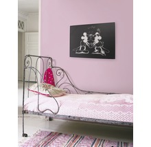 Zimmer mit Wandbild, Bett und Teppich.